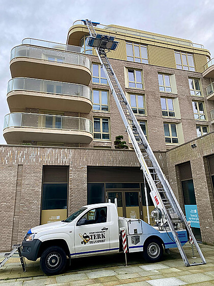 Verhuislift op de pick-up van Verhuisbedrijf Sterk Transport bij een appartementencomplex
